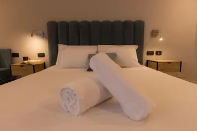a large bed with white sheets and pillows at Villa Borghese Prestige Rooms in Rome