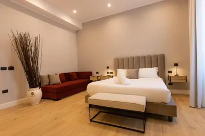 a bedroom with a large bed and a red couch at Villa Borghese Prestige Rooms in Rome