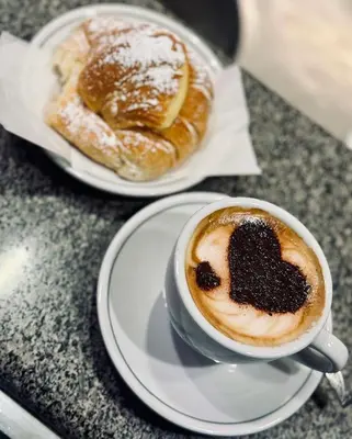 a cup of coffee and two pastries on a table at Fefe's House in Rome