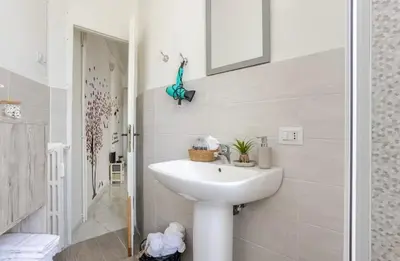 a white bathroom with a sink and a mirror at Fefe's House in Rome