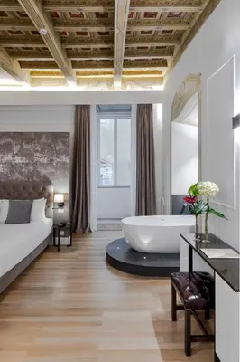 a bedroom with a bed and a tub in a room at Palazzo Goldoni Condotti Collection in Rome