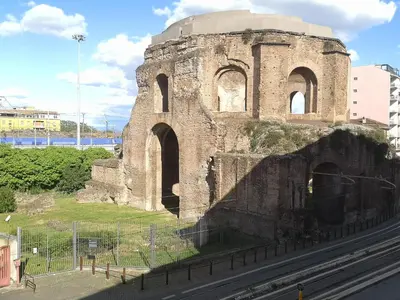 an old brick building with arches next to a street at Gio's home in Rome