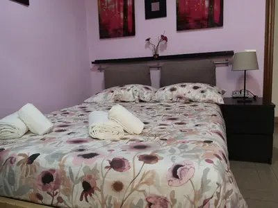 a bedroom with a bed with a floral bedspread and pillows at Gio's home in Rome