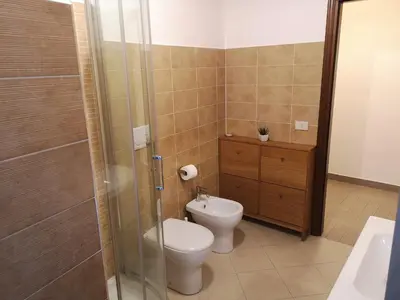 a bathroom with a toilet and a glass shower at Gio's home in Rome