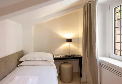 a bedroom with a bed and a desk next to a window at Viam Villa Futura in Rome