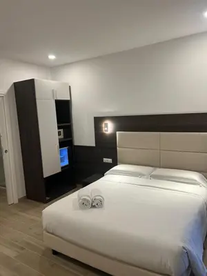 a bedroom with a large white bed with two towels at Garden Of Vatican's in Rome