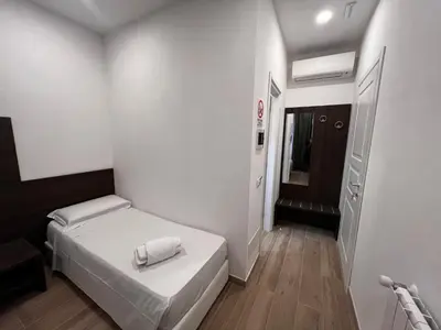 a small room with a bed and a hallway at Garden Of Vatican's in Rome