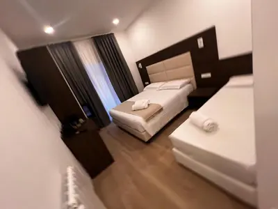 a hotel room with two beds and a window at Garden Of Vatican's in Rome