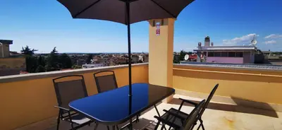 a blue table and chairs on a balcony with an umbrella at Penthouse loft with view in Rome