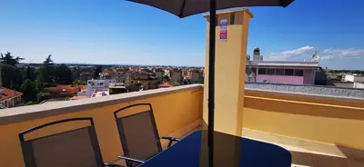 a balcony with a chair and an umbrella on a roof at Penthouse loft with view in Rome