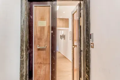 a hallway with a wooden door and a hallway leading into a room at Coliseum sweet guest house in Rome