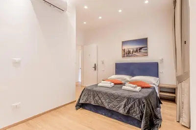 a bedroom with a large bed with orange pillows at Coliseum sweet guest house in Rome