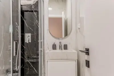 a white bathroom with a sink and a mirror at Coliseum sweet guest house in Rome