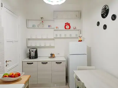 a kitchen with a white refrigerator and a bowl of fruit at [Rome] House with garden near the Olympic Stadium in Rome