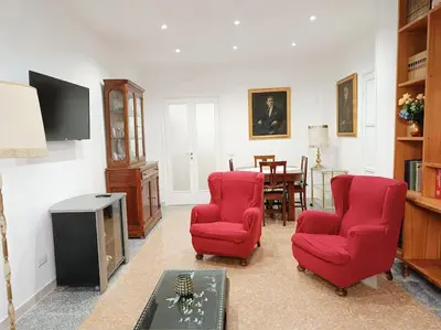a living room with two red chairs and a table at [Rome] House with garden near the Olympic Stadium in Rome