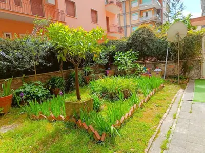 a garden with trees and plants in front of a building at [Rome] House with garden near the Olympic Stadium in Rome