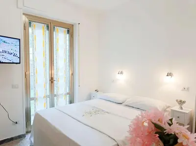 a white bedroom with a bed and a window at [Rome] House with garden near the Olympic Stadium in Rome