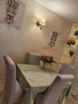 a table with chairs and a vase of flowers on it at Crismi house in Rome