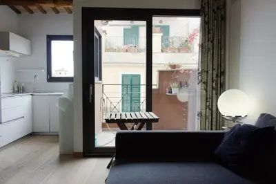 a living room with a couch and a large window at Stylish Penthouse with terrace in Trastevere in Rome