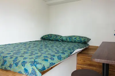 a small bed in a room with a table at Stylish Penthouse with terrace in Trastevere in Rome