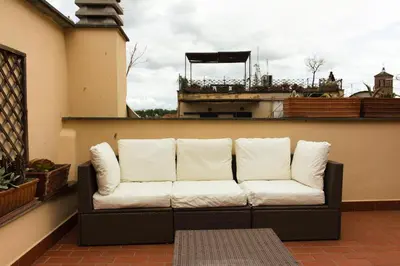 a couch sitting on top of a balcony at Stylish Penthouse with terrace in Trastevere in Rome