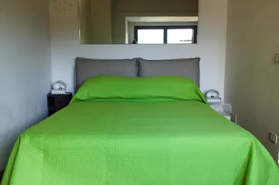 a bed with a green comforter in a bedroom at Stylish Penthouse with terrace in Trastevere in Rome