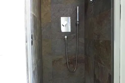 a shower with a hose in a bathroom at Stylish Penthouse with terrace in Trastevere in Rome