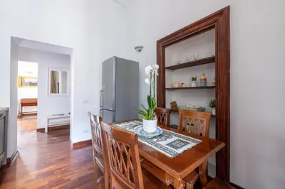 a dining room with a table and chairs and a refrigerator at Luxury apartment in the Heart of Rome - near metro A and B in Rome
