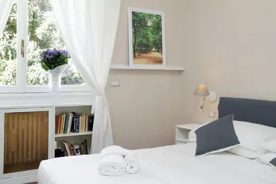 a bedroom with a bed and a window with a book shelf at Vatican Art House in Rome