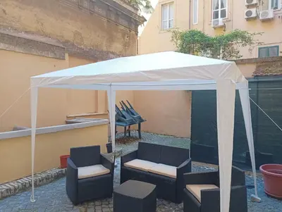 a white tent with chairs and chairs under it at Domus Fanti in Rome