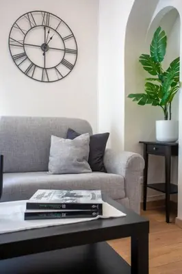 a living room with a couch and a clock on the wall at MyRentalInn - Rome - Trastevere Arch Suite in Rome