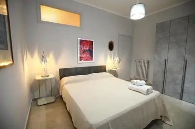 a bedroom with a large white bed and two lamps at Viale Trastevere Apartment in Rome