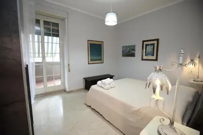 a white bedroom with a bed and a window at Viale Trastevere Apartment in Rome