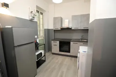 a small kitchen with a refrigerator and a sink at Viale Trastevere Apartment in Rome