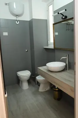 a bathroom with a sink and a toilet and a mirror at Viale Trastevere Apartment in Rome