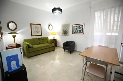 a living room with a green couch and a table at Viale Trastevere Apartment in Rome