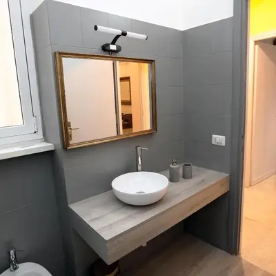 a bathroom with a white sink and a mirror at Viale Trastevere Apartment in Rome