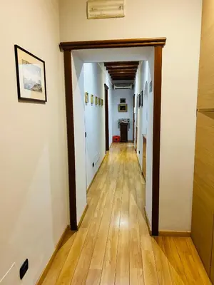 a hallway of an apartment with white walls and wooden floors at Cenci Guest House in Rome