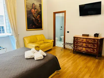 a bedroom with a bed and a yellow couch at Cenci Guest House in Rome