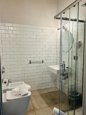 a bathroom with a shower and a toilet and a sink at Cenci Guest House in Rome