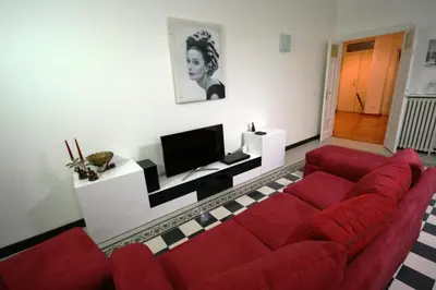 a living room with a red couch and a tv at Irene's Home The Residence in Rome