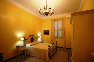a bedroom with a bed and a chandelier at Irene's Home The Residence in Rome