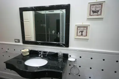 a bathroom with a black sink and a mirror at Irene's Home The Residence in Rome