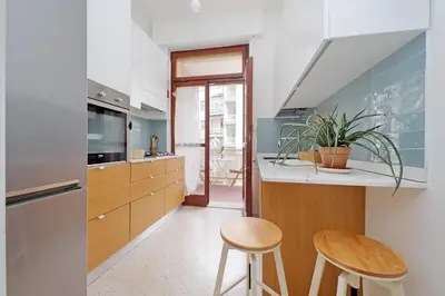 a kitchen with a counter and two stools in it at YCH-Appartamento Luminoso a San Pietro in Rome