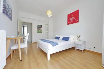 a bedroom with a white bed and a table and a desk at YCH-Appartamento Luminoso a San Pietro in Rome