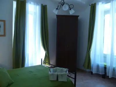a bedroom with a green bed and a dresser at Holiday Home Il Sogno A San Pietro in Rome