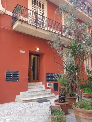 a red building with stairs and a balcony at Holiday Home Il Sogno A San Pietro in Rome