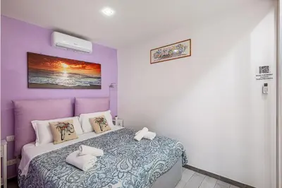 a bedroom with purple walls and a bed with pillows at Deluxe Apartments Pantheon in Rome