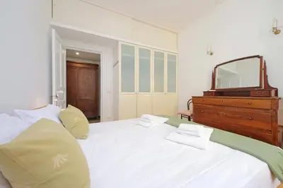 a bedroom with a large white bed with a mirror at suity I cozy belli apartment in Rome