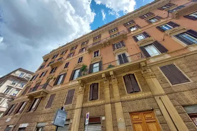 a tall brick building with windows and a balcony at suity I cozy belli apartment in Rome